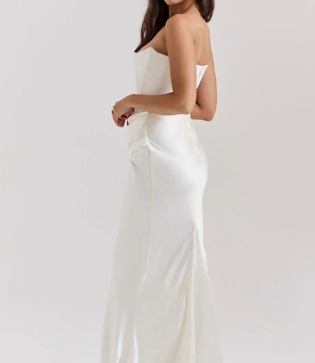 Side profile of a white strapless sweetheart corset maxi dress, highlighting the satin fabric and elegant drape.