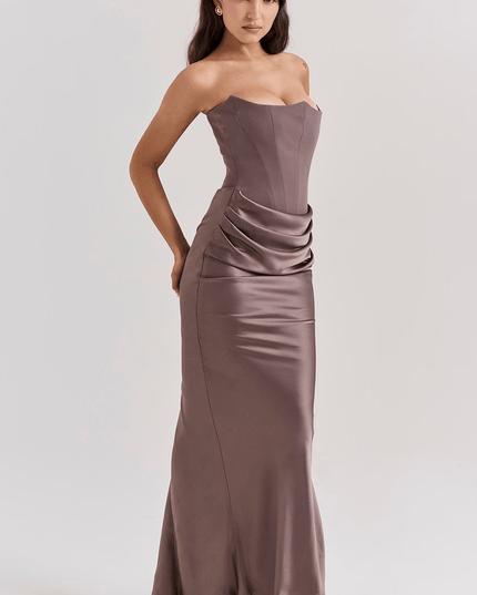 Side view of a women's taupe strapless maxi dress featuring a sweetheart neckline and elegant draped skirt.