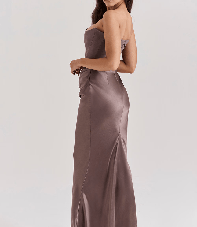 Three-quarter back view of a women's taupe strapless sweetheart corset maxi dress, showcasing the fitted silhouette.