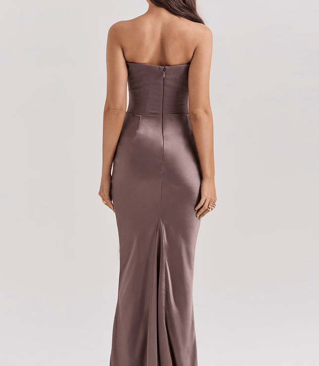 Back view of a women's taupe strapless sweetheart corset maxi dress with a subtle slit at the hem.