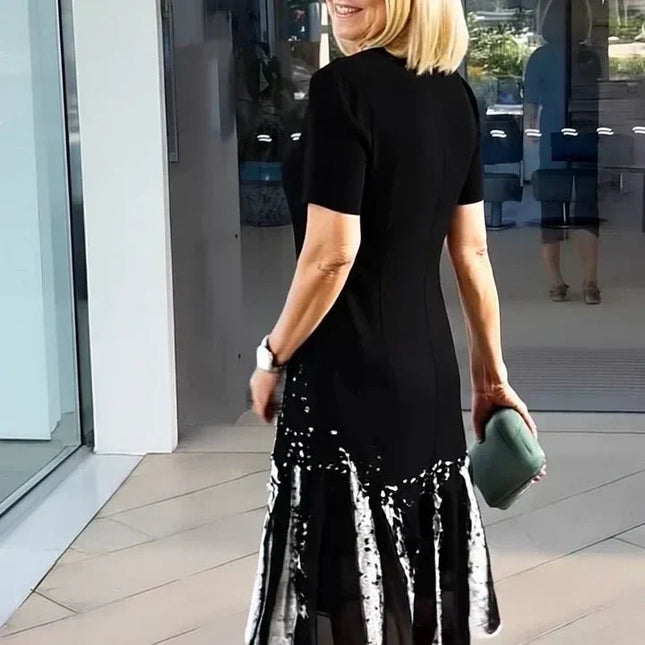 Back view of black midi dress with white abstract splatter hem and fitted short sleeves