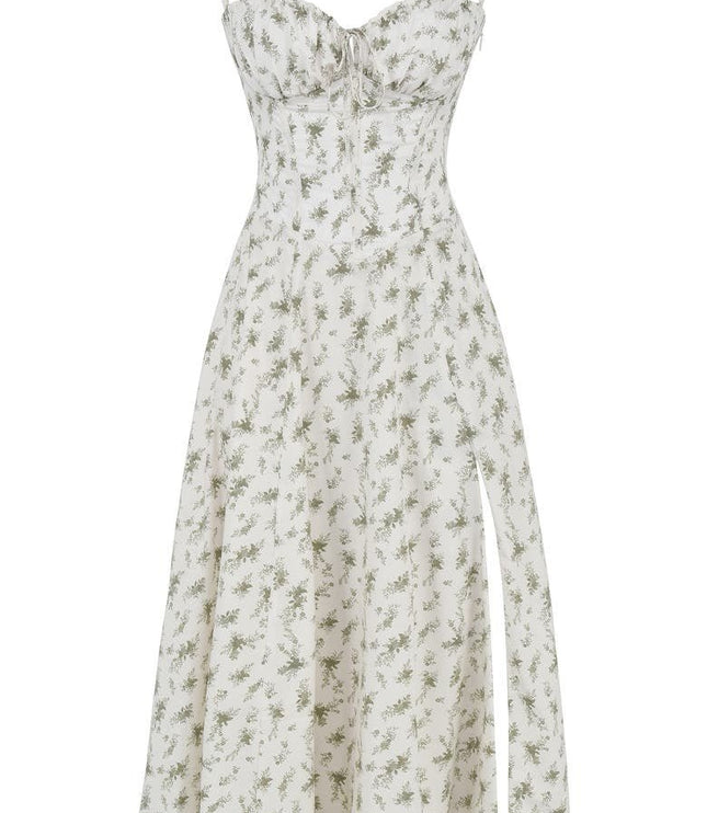 Flat lay of a white floral midi dress with subtle green print, corset bodice, and high side split.