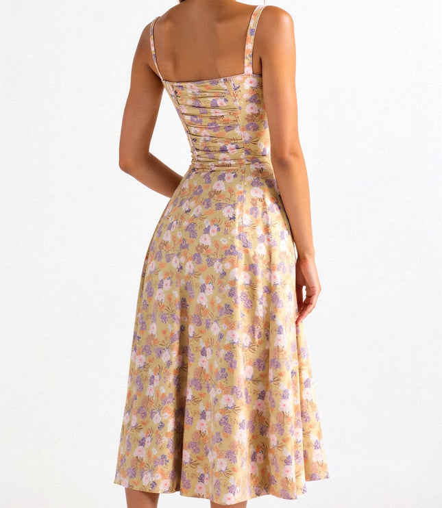 Back view of yellow floral midi dress with ruched elastic back, pink and purple flower pattern, and thin straps.