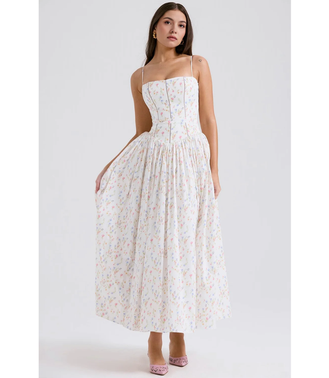 White floral maxi dress with gathered waist, thin straps, and flowing skirt
