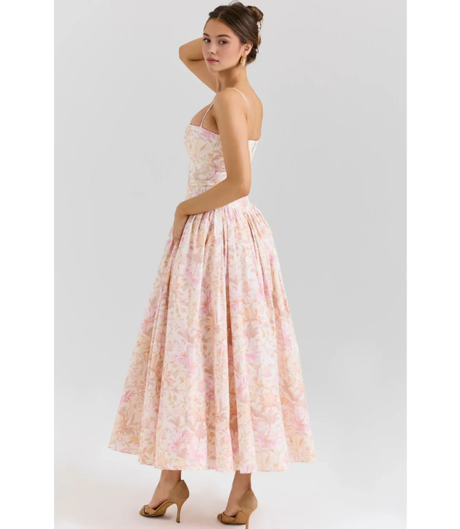 Back view of pastel floral maxi dress with open back, thin straps, and gathered waist