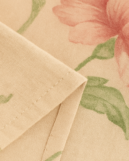 Close-up of pink peony and green leaf fabric texture on summer midi dress