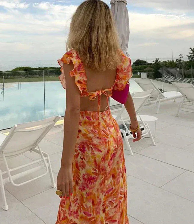 Back view of floral ruffle maxi dress with open back tie detail and flutter sleeves