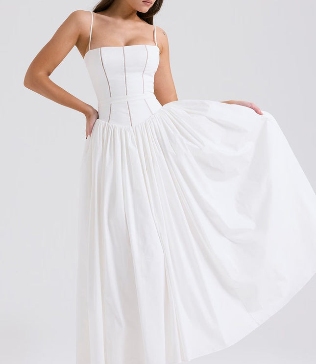 Women's white spaghetti strap midi dress with a full skirt, shown with hands on hips, highlighting the flowy fabric and fitted bodice.