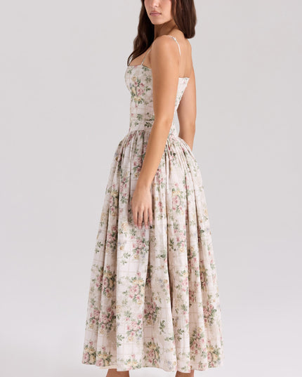 Back view of a women's floral midi dress in cream with pink and green flowers, highlighting the spaghetti straps and elegant silhouette.