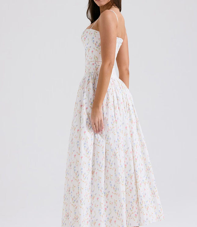 Profile view of a white floral spaghetti strap midi dress, showcasing the full skirt and delicate print.