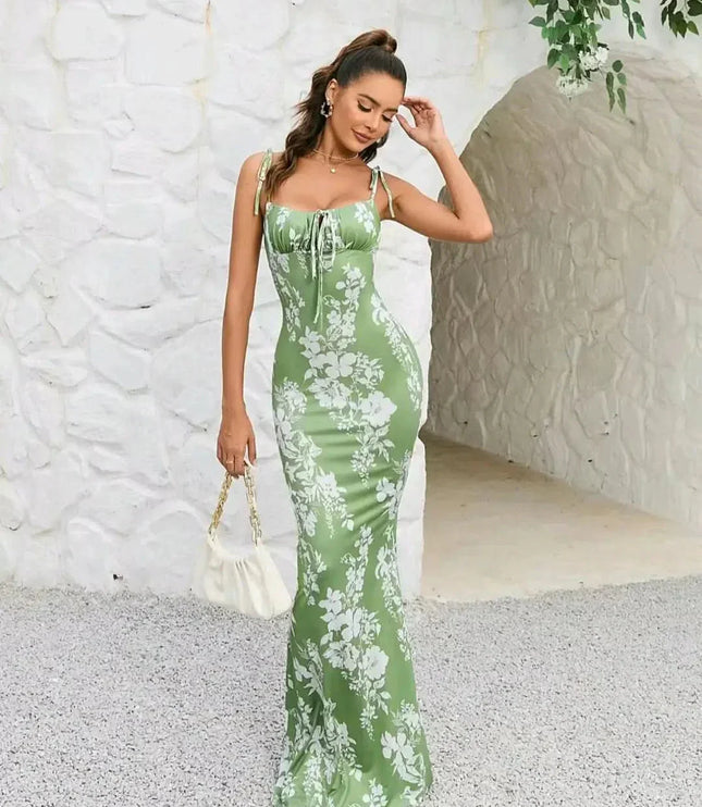 Side view of green floral maxi dress with square neckline, tie straps, and sleek bodycon fit