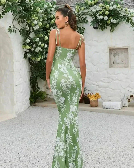 Back view of green floral maxi dress with open back, tie shoulder straps, and long fitted skirt