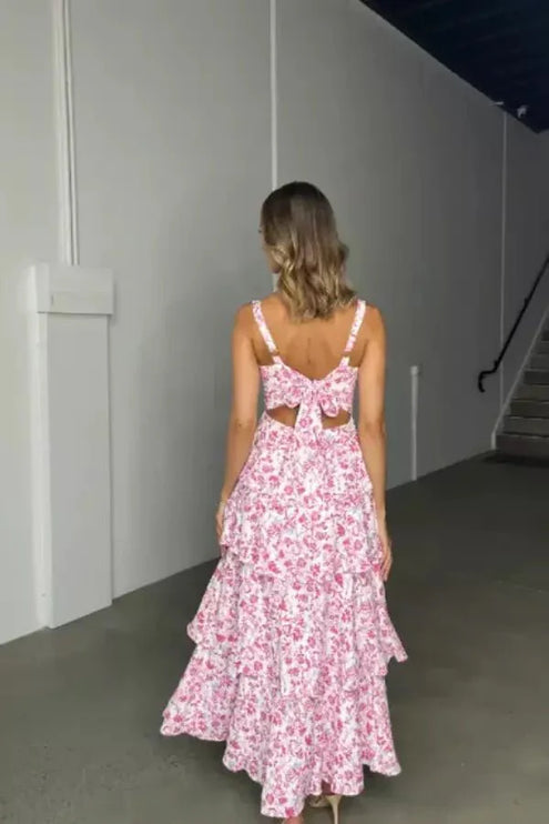Back view of pink floral midi dress with open back bow detail and tiered skirt