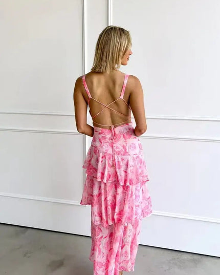 Back view of pink floral V neck maxi dress with crisscross straps and tiered skirt