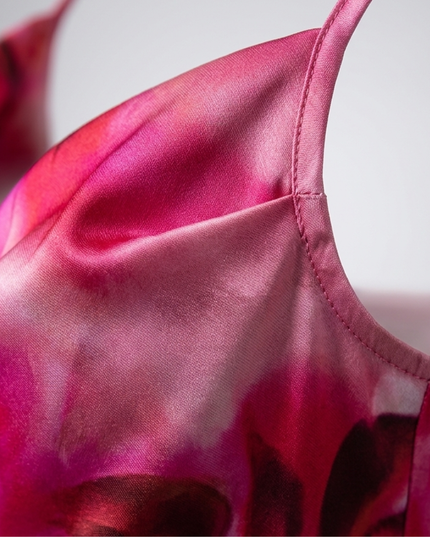 Close-up of pink floral satin fabric on a women's summer dress with thin strap