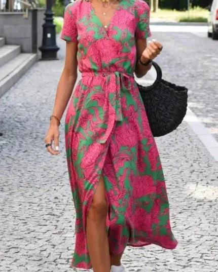 Front view of a pink and green floral midi dress with V neck, short sleeves and wrap skirt