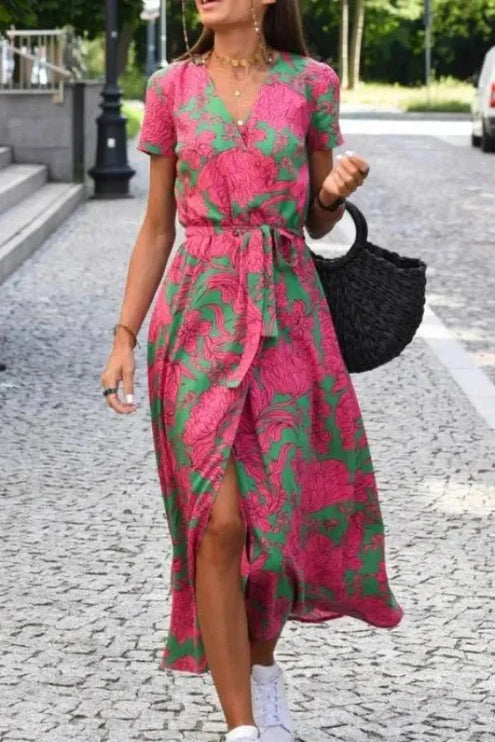 Front view of a pink and green floral midi dress with V neck, short sleeves and wrap skirt
