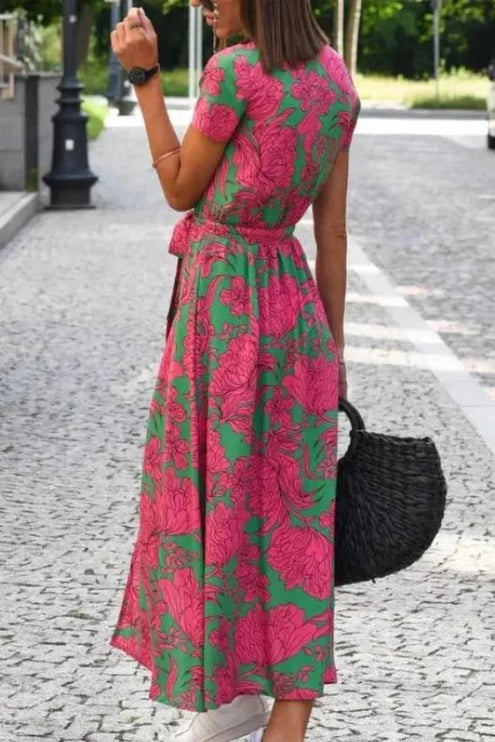 Back view of floral midi dress with pink and green pattern, short sleeves, and flowing skirt