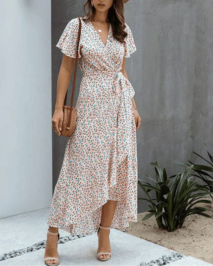 Pink floral V neck midi dress with short flutter sleeves, wrap front, and asymmetrical hem