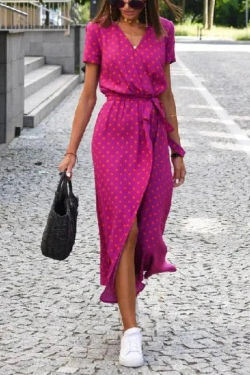 Front view of a magenta polka dot midi dress with V neck, short sleeves and wrap skirt