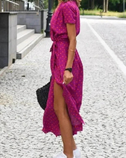 Side view of a magenta polka dot summer dress with V neck, tie waist and midi length hem