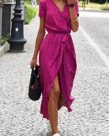 Front view of a magenta polka dot midi dress with V neck, short sleeves and front slit