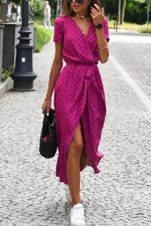 Front view of a magenta polka dot midi dress with V neck, short sleeves and front slit