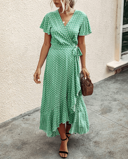 Green polka dot wrap midi dress with V neck, flutter sleeves, and ruffled high-low hem