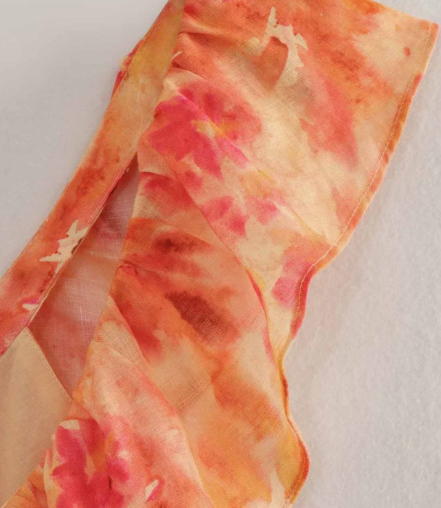 Close-up of orange floral maxi dress shoulder strap and sheer fabric texture detail