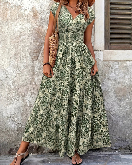 Full length view of a women's floral V-neck maxi dress in green, featuring a shirred bodice and flowing skirt.