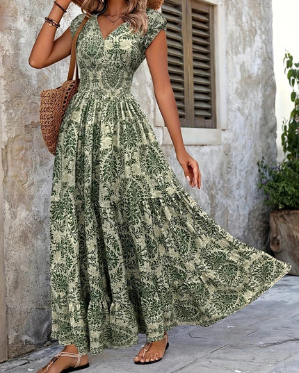 Side view of a women's green floral maxi sundress, showing the movement of the tiered skirt and V-neckline.