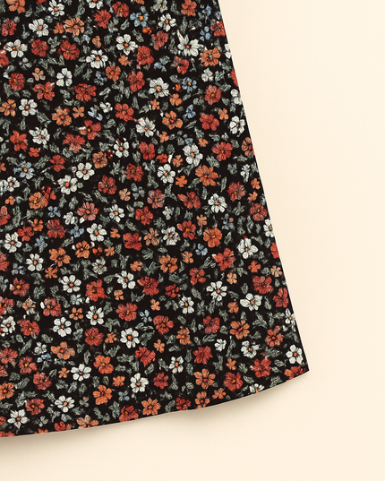 Close-up of red, white and orange floral print on black fabric
