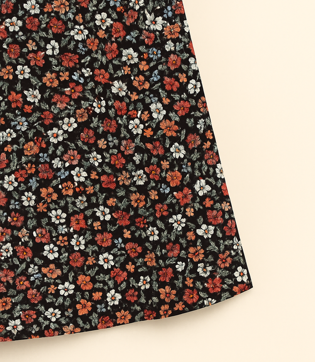 Close-up of red, white and orange floral print on black fabric