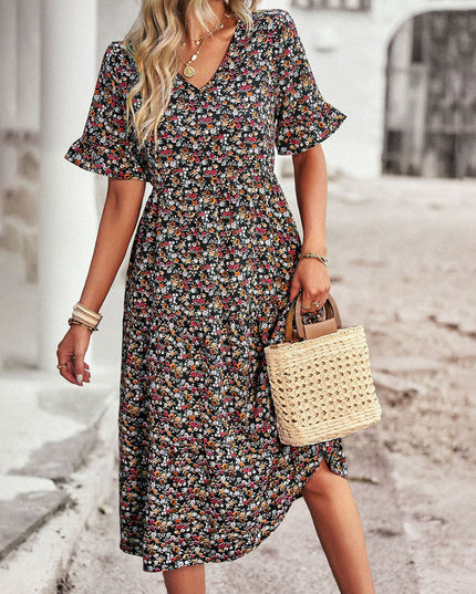 Black floral midi dress with v-neck worn with straw tote bag