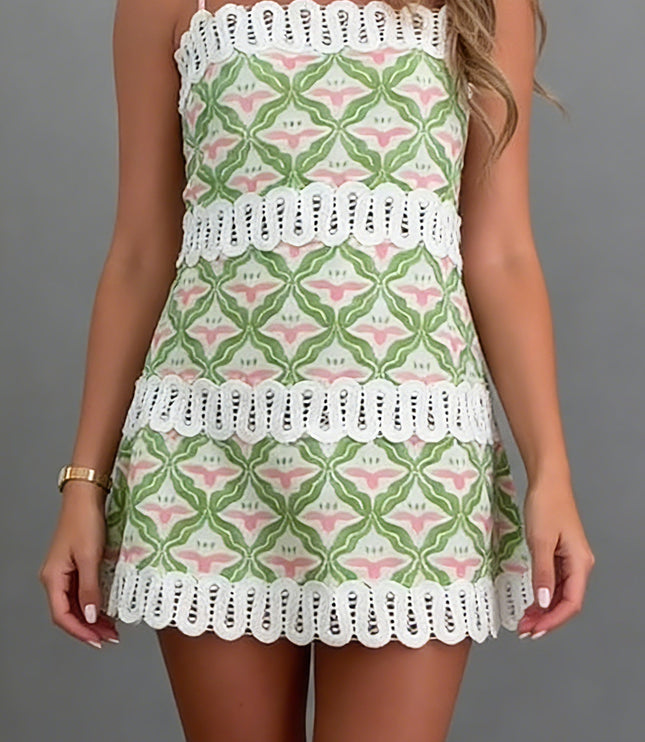 Front full view of summer mini dress with geometric floral pattern and white eyelet trim