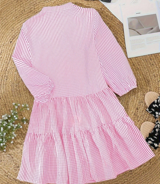Pink gingham mini dress laid flat, showing V neck, button front, and tiered skirt