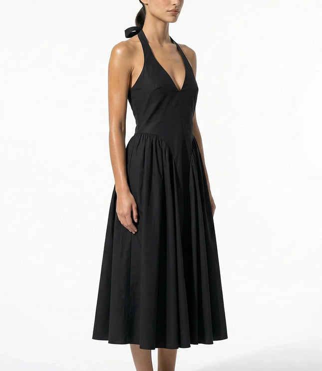 Side view of black halter midi dress showing fitted bodice and flowing skirt