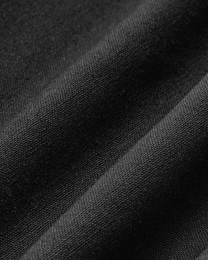 Close-up of black pleated maxi skirt fabric showing smooth textured weave and soft drape