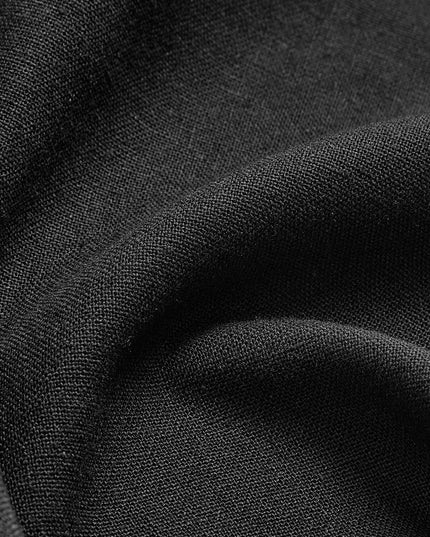 Detailed close-up of black maxi skirt material with fine texture and layered pleats