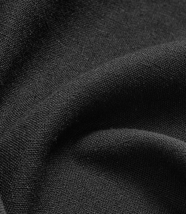 Detailed close-up of black maxi skirt material with fine texture and layered pleats