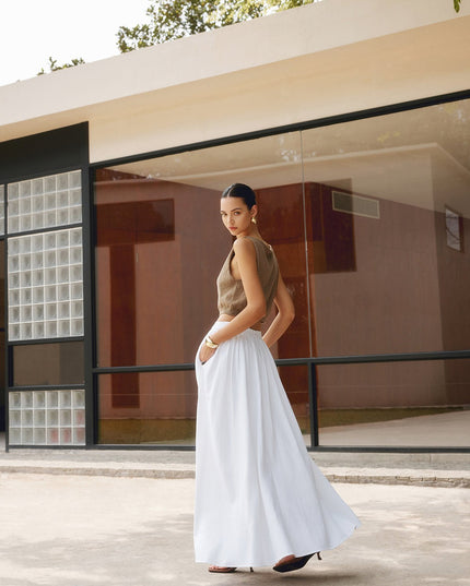 Side view of white high waisted maxi skirt with pleats and ankle-length flow