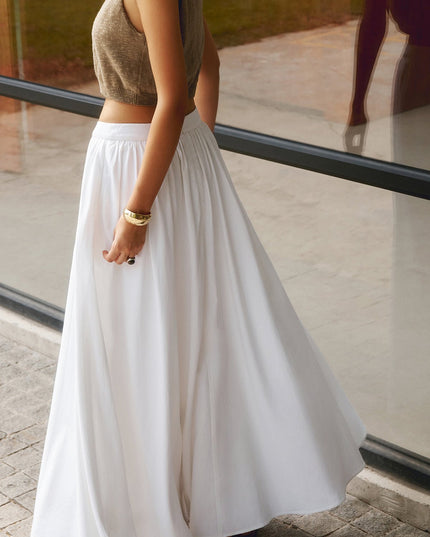 Close-up of white high waisted pleated maxi skirt with gathered waistband and zipper back