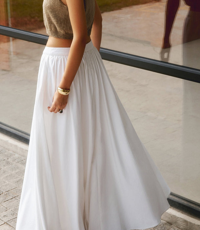 Close-up of white high waisted pleated maxi skirt with gathered waistband and zipper back