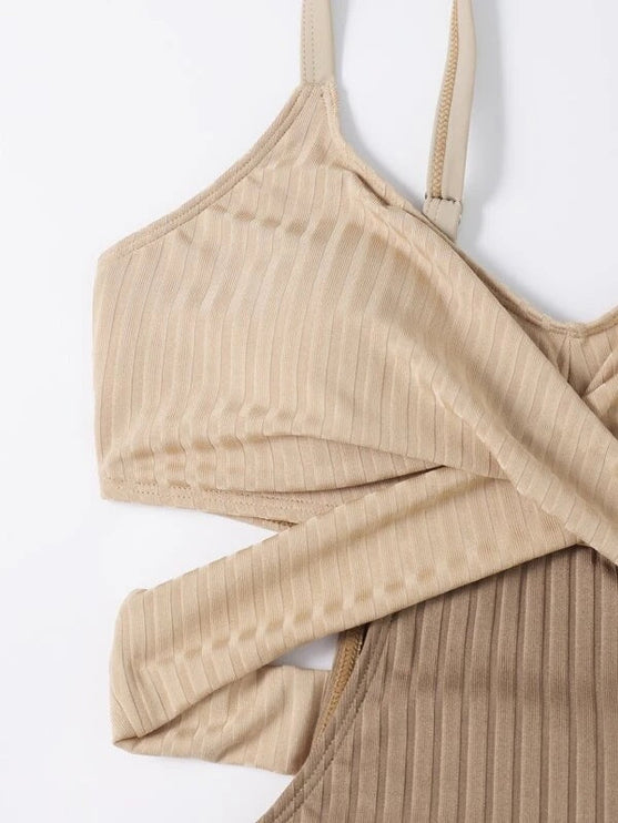 Close up of beige ribbed swimsuit showing crisscross cut out top and textured fabric detail