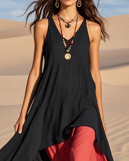 Close-up of the black V-neck asymmetrical midi sundress with red lining and layered necklaces.