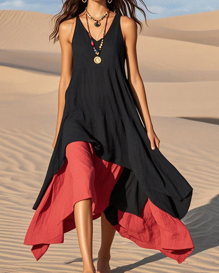 Full body view of the women's black and red asymmetrical midi sundress walking on sand.