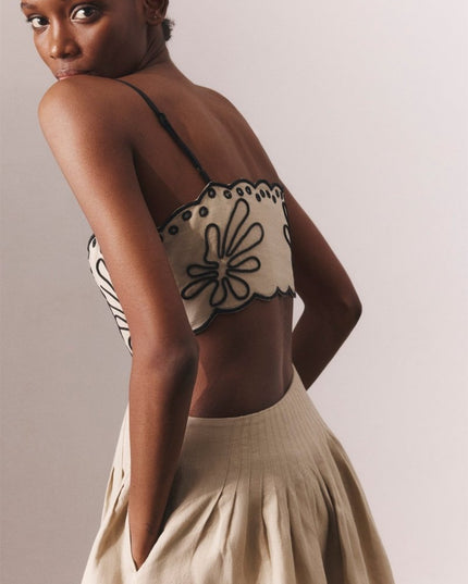 Back view of beige floral embroidery midi dress with open back and thin straps