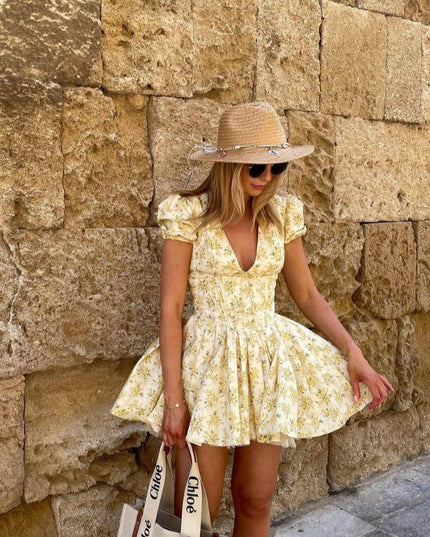 Yellow floral V neck mini dress with puff sleeves and full skirt styled with straw hat