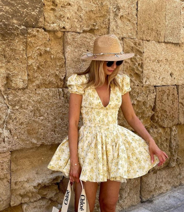 Yellow floral V neck mini dress with puff sleeves and full skirt styled with straw hat