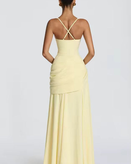 Back view of yellow formal maxi dress showing crossback straps and asymmetrical draping